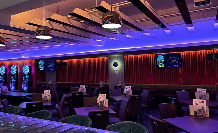 天井のラインライトが映える店内、ゆったり席でダーツ前の待ち時間も心地いい